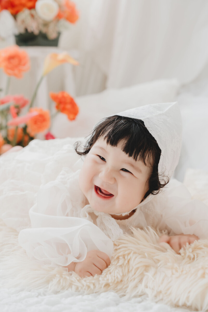 大阪・上本町で撮影したオレンジと赤の花に囲まれた1歳記念フォト